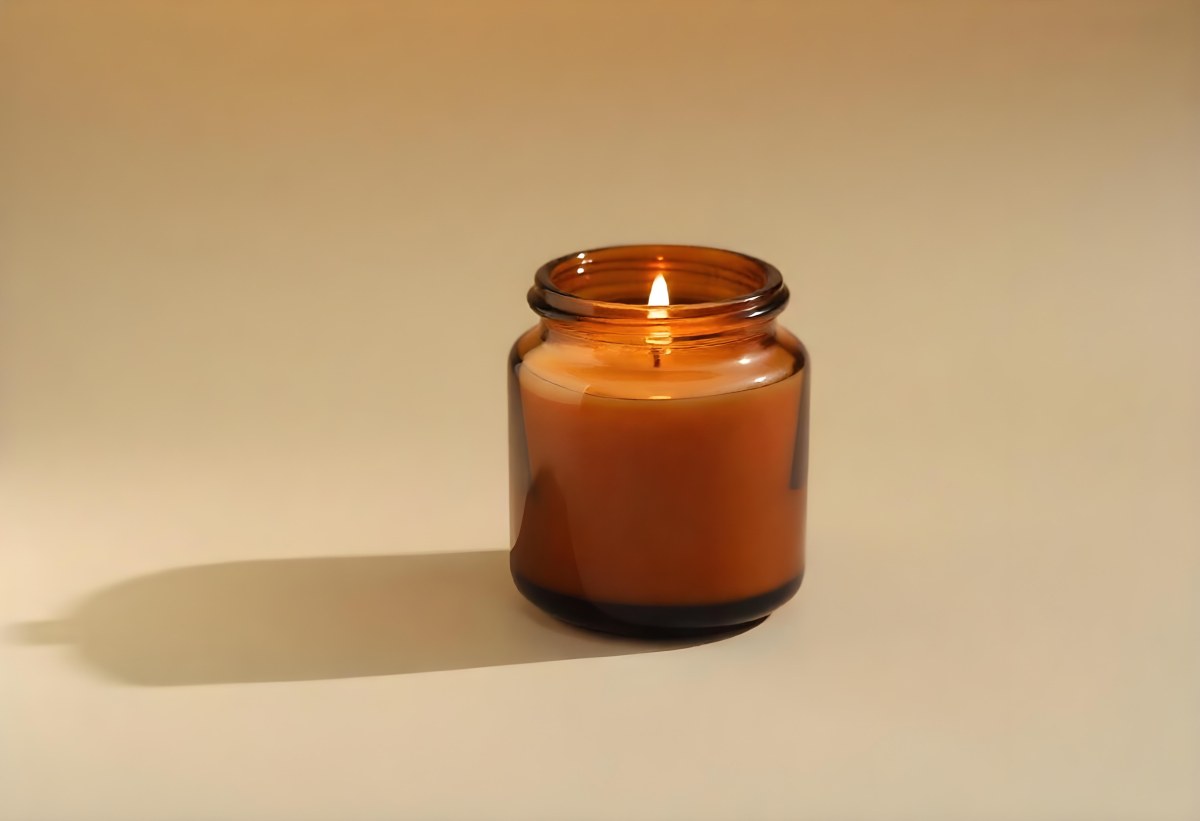 A Brown Glass Jar Candle With A Flickering Flame Casting Soft Shadows On A Neutral Surface Minimalist Aesthetic Warm Lighting Simple Composition Cozy Atmosphere 7 59a7