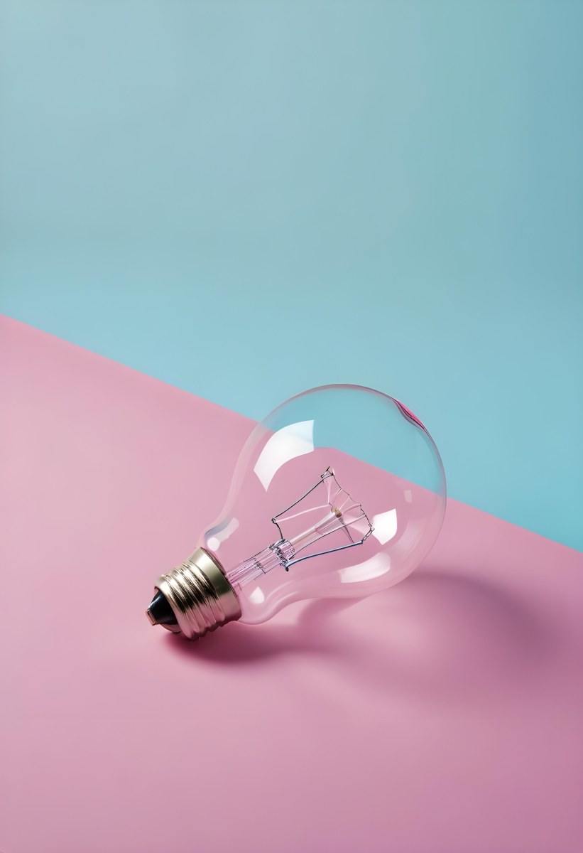 A Clear Light Bulb Lying On A Pink Surface With A Blue Background The Bulb Has A Classic Filament Design Visible Inside The Color Contrast Between The Pink And Blue Creates A Vibrant Aesthetic 15 3a1f