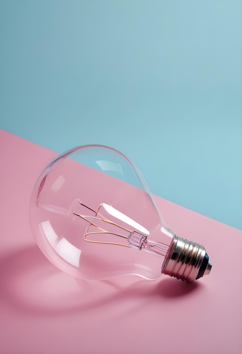 A Clear Light Bulb Lying On A Pink Surface With A Blue Background The Bulb Has A Classic Filament Design Visible Inside The Color Contrast Between The Pink And Blue Creates A Vibrant Aesthetic 5 B491