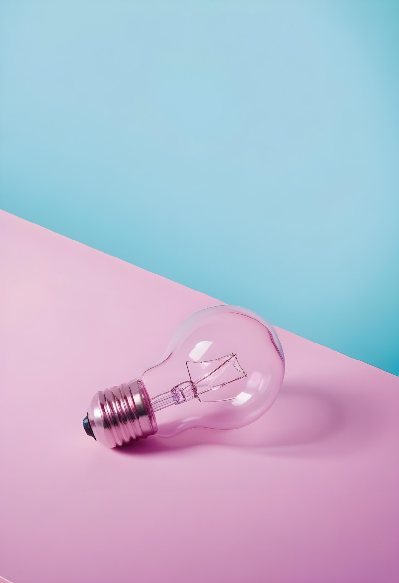 A Clear Light Bulb Lying On A Pink Surface With A Blue Background The Bulb Has A Classic Filament Design Visible Inside The Color Contrast Between The Pink And Blue Creates A Vibrant Aesthetic 6 Aea1