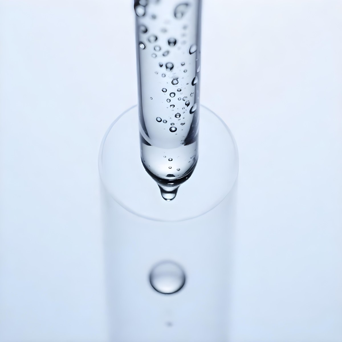 A Close Up Of A Glass Pipette With Water Droplets Against A Blue Background 1 Dfaa
