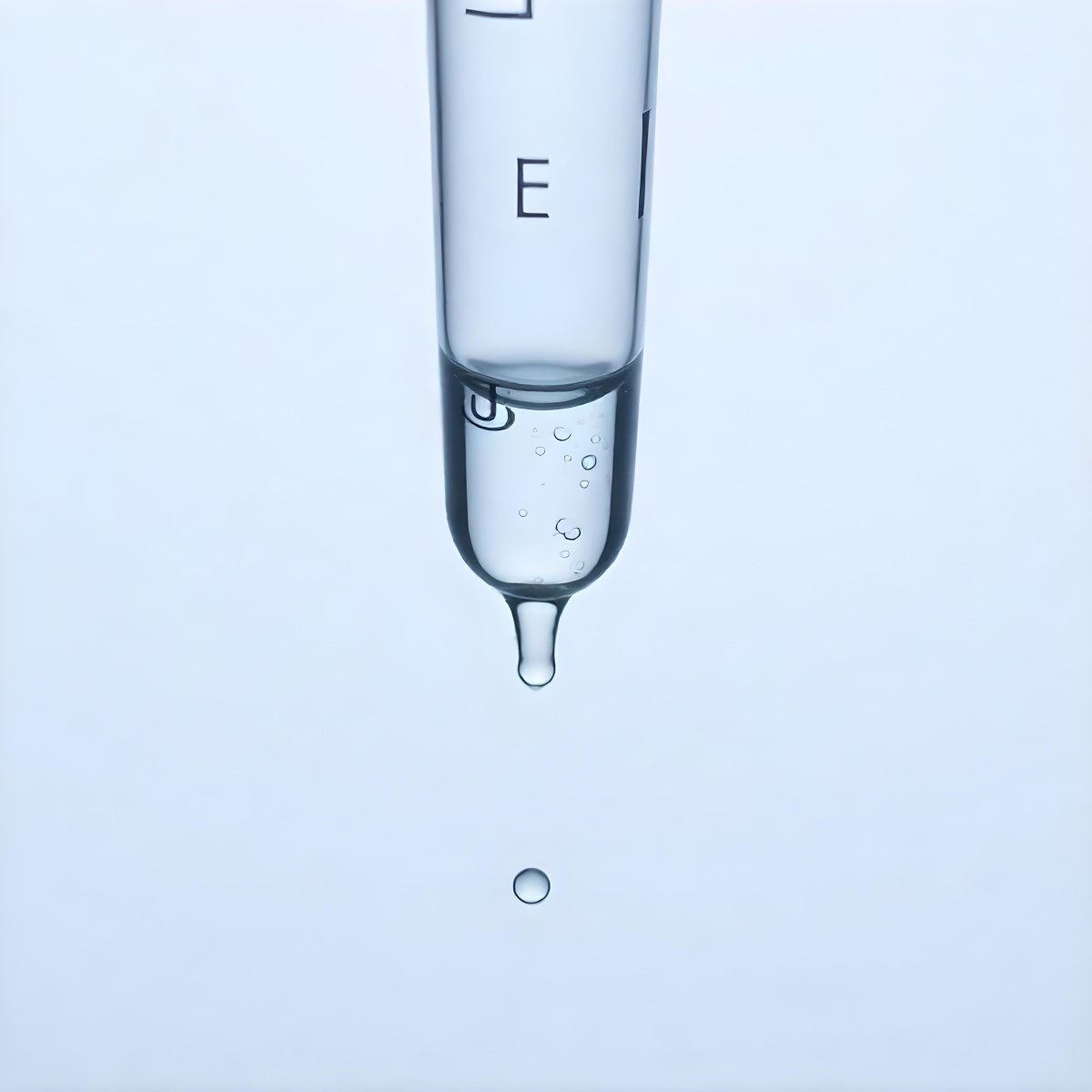 A Close Up Of A Glass Pipette With Water Droplets Against A Blue Background 2 2433