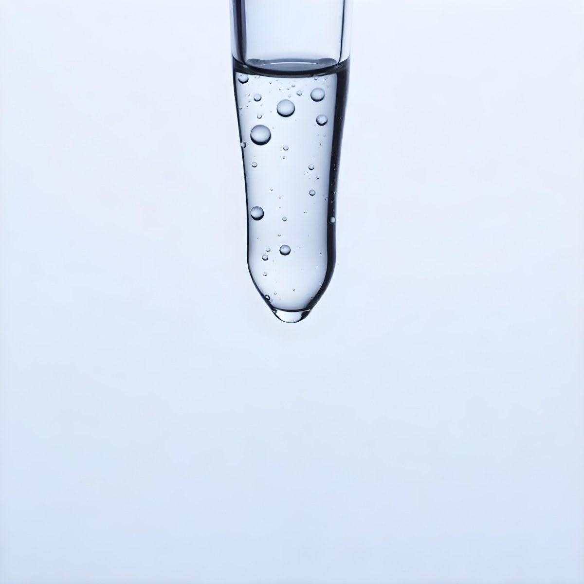 A Close Up Of A Glass Pipette With Water Droplets Against A Blue Background 3 590b