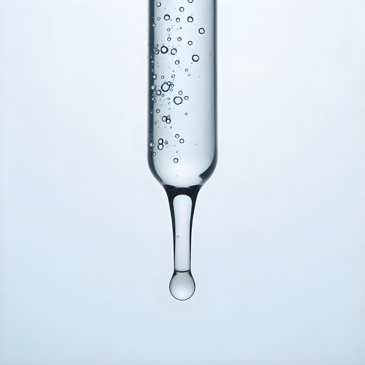 A Close Up Of A Glass Pipette With Water Droplets Against A Blue Background 4 751e