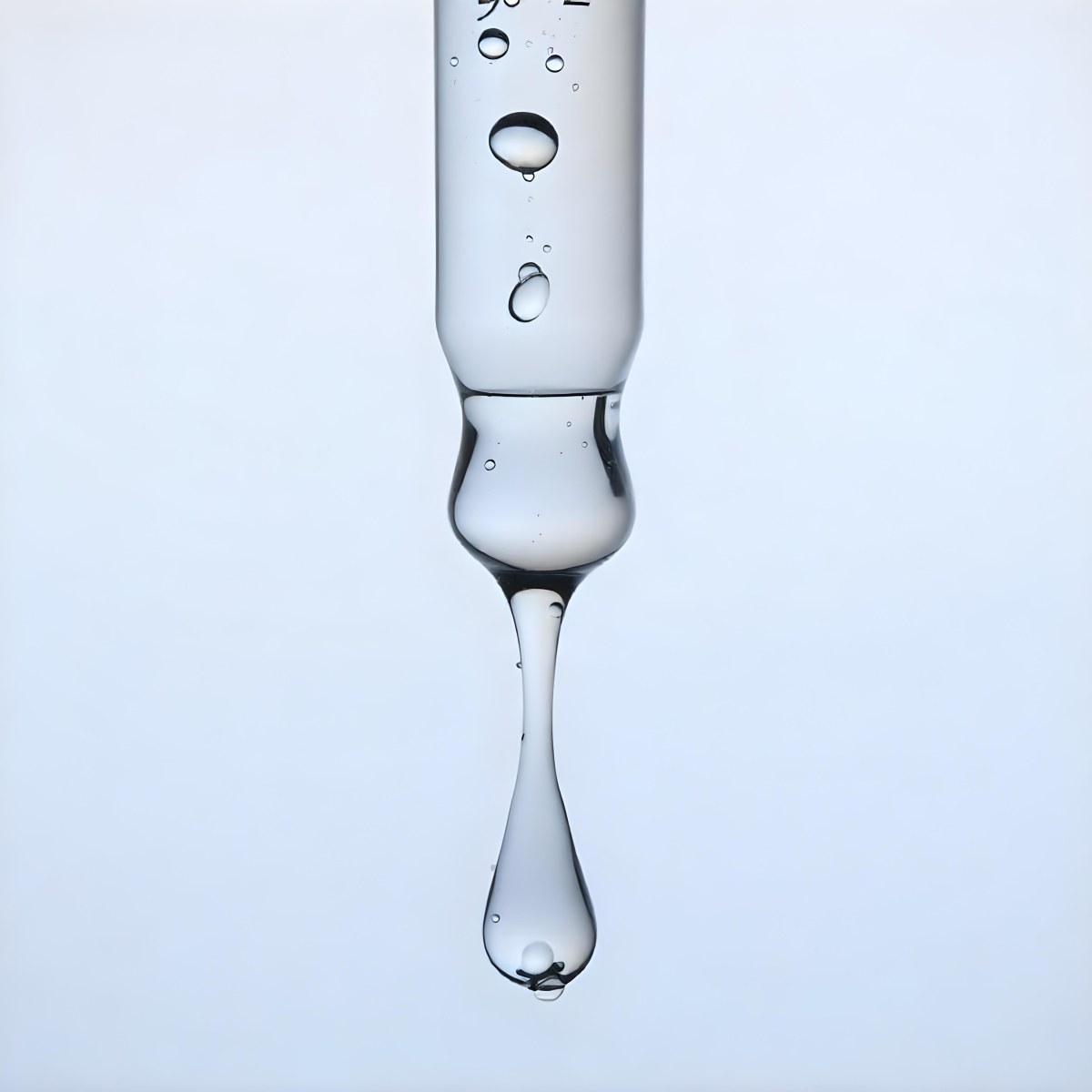 A Close Up Of A Glass Pipette With Water Droplets Against A Blue Background 6 F2fa