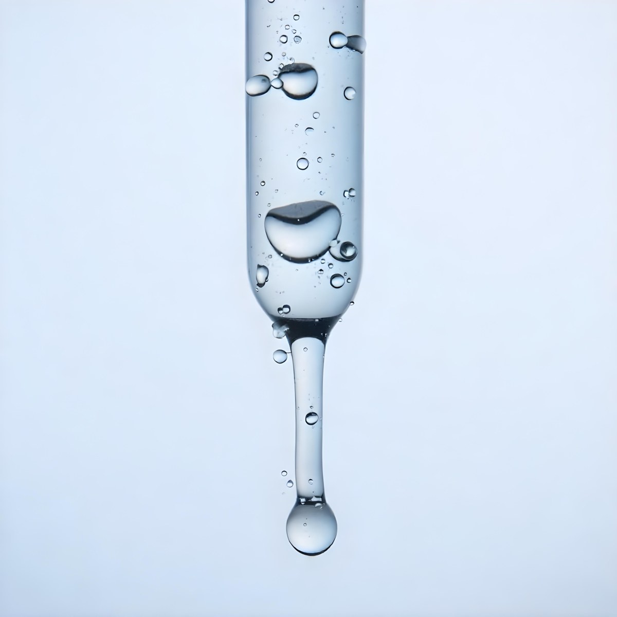A Close Up Of A Glass Pipette With Water Droplets Against A Blue Background 7 5103