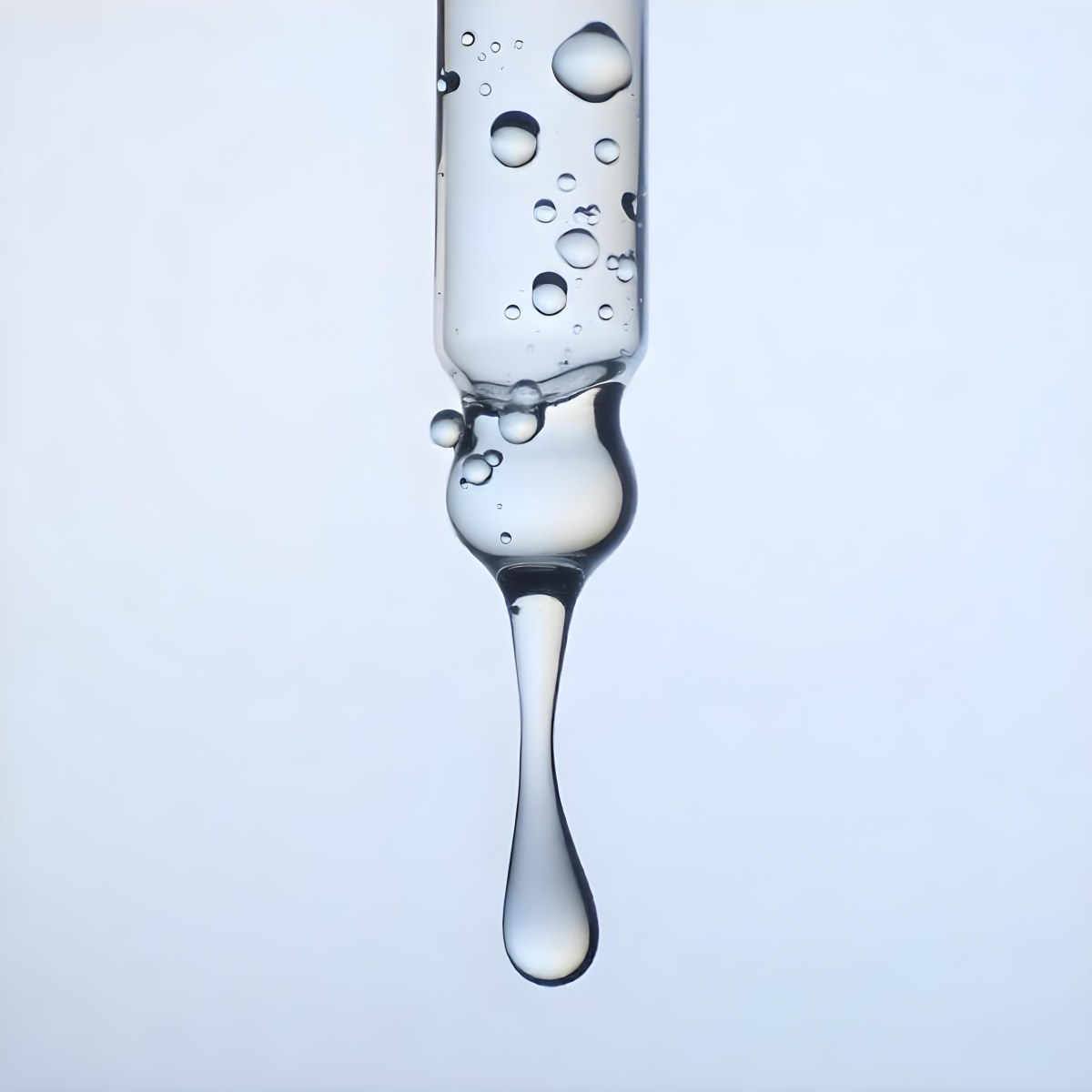 A Close Up Of A Glass Pipette With Water Droplets Against A Blue Background 9 C2f9