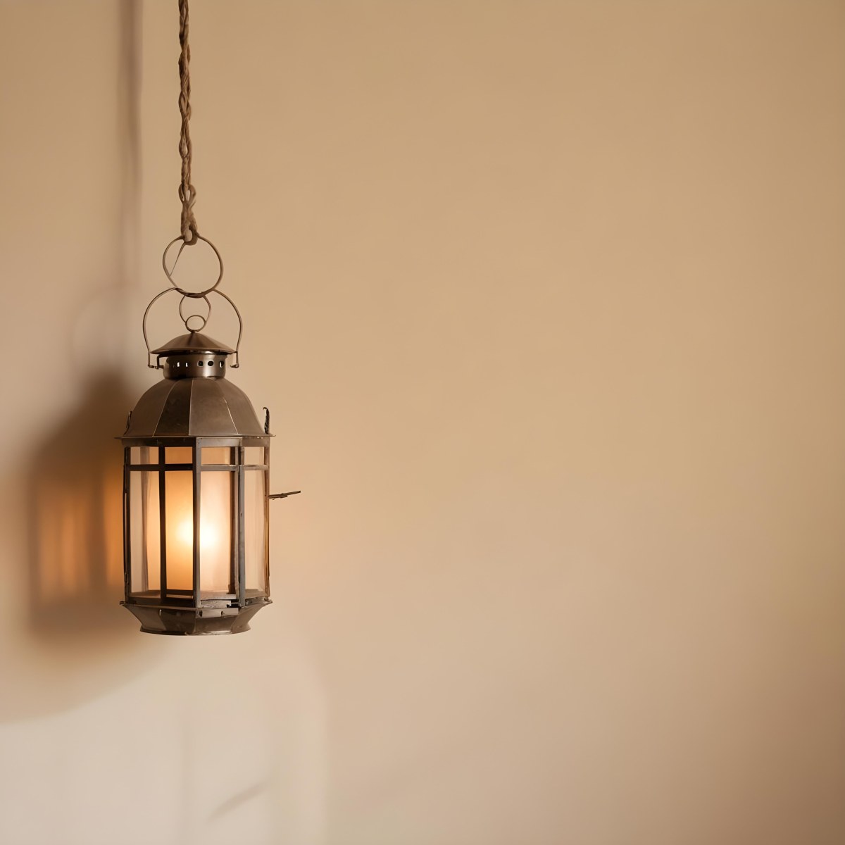 A Hanging Lantern With A Warm Glowing Light Against A Plain Beige Wall 7 8820
