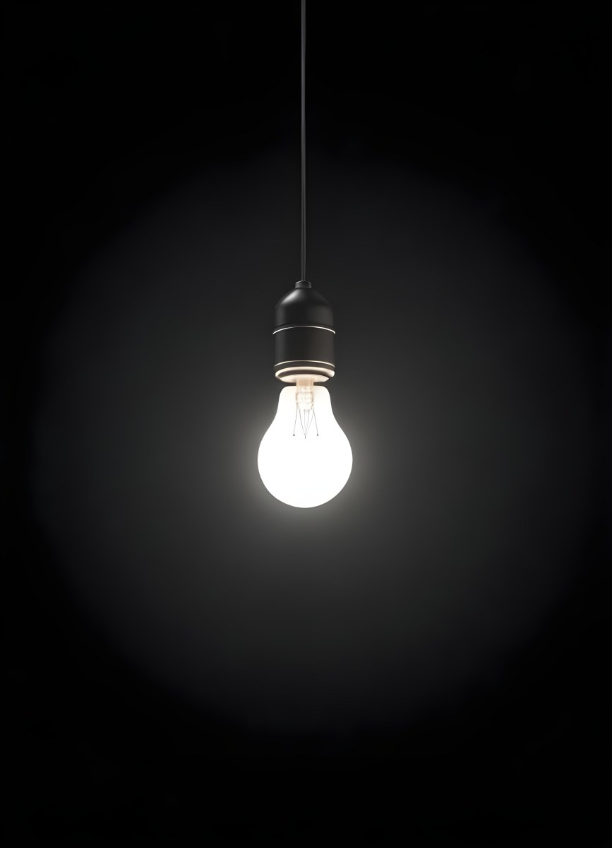 A Light Bulb Hanging From The Ceiling The Bulb Is Glowing Brightly The Background Is Black The Light Is Casting A Soft Glow 21 C017
