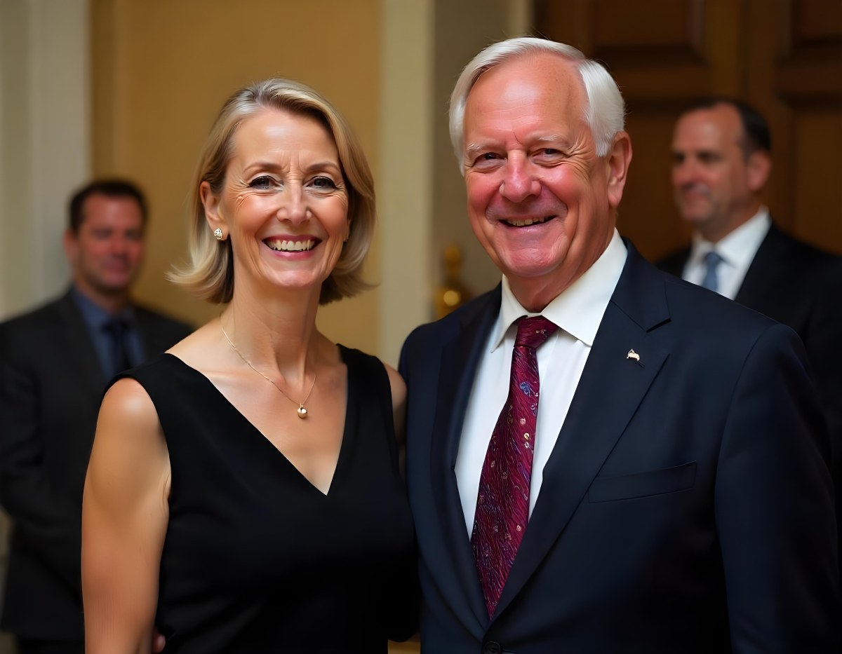 A Middle Aged Caucasian Woman With Short Blonde Hair And A Middle Aged Caucasian Man With Gray Hair And Glasses Both Smiling And Dressed Formally 5 7d14