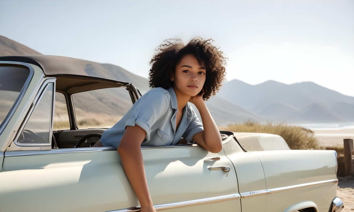 A Young Black Woman With Curly Hair Looking Out The Window Of A Vintage Car On A Sunny Beach With Mountains In The Background 2 A58a