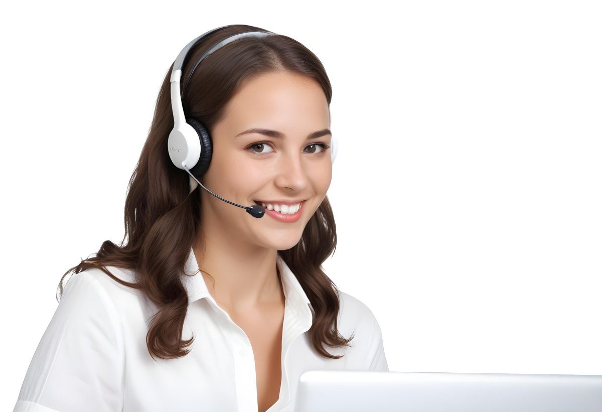 A Young Caucasian Woman Approximately 25 Years Old With Long Wavy Brown Hair Wearing A White Shirt And A Headset With A Microphone She Is Smiling And Looking Directly At The Camera With A Laptop Visible In The Foreg 38 Bfc6