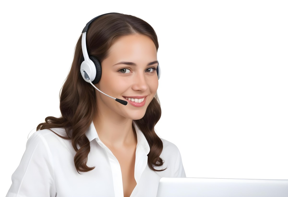 A Young Caucasian Woman Approximately 25 Years Old With Long Wavy Brown Hair Wearing A White Shirt And A Headset With A Microphone She Is Smiling And Looking Directly At The Camera With A Laptop Visible In The Foreg 41 4a32