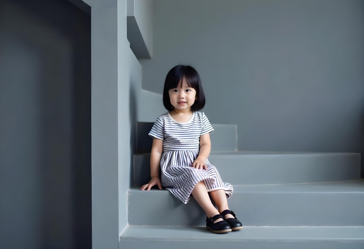 An Asian Girl 6 Years Old Black Hair Sitting On Gray Stairs Wearing A Striped Dress And Black Shoes Gray Background 36 A8b1