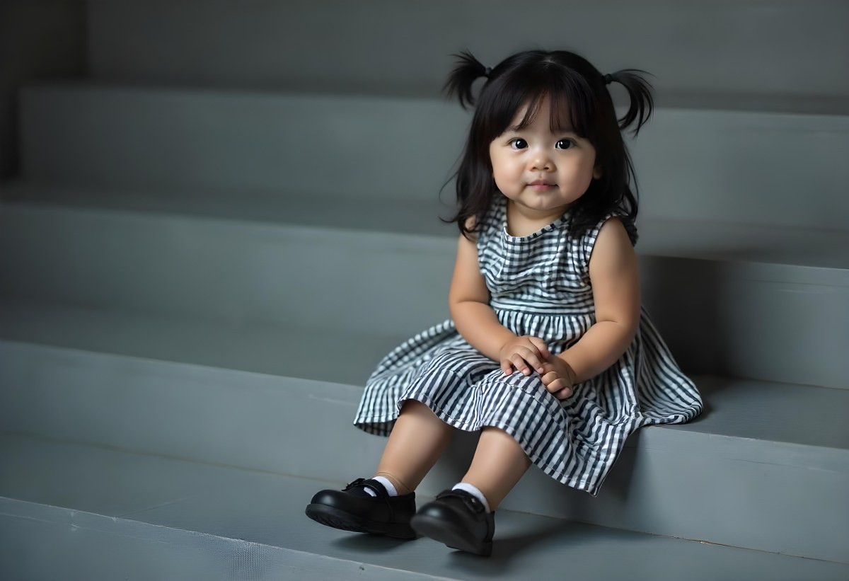 An Asian Girl 6 Years Old Black Hair Sitting On Gray Stairs Wearing A Striped Dress And Black Shoes Gray Background 6 929b