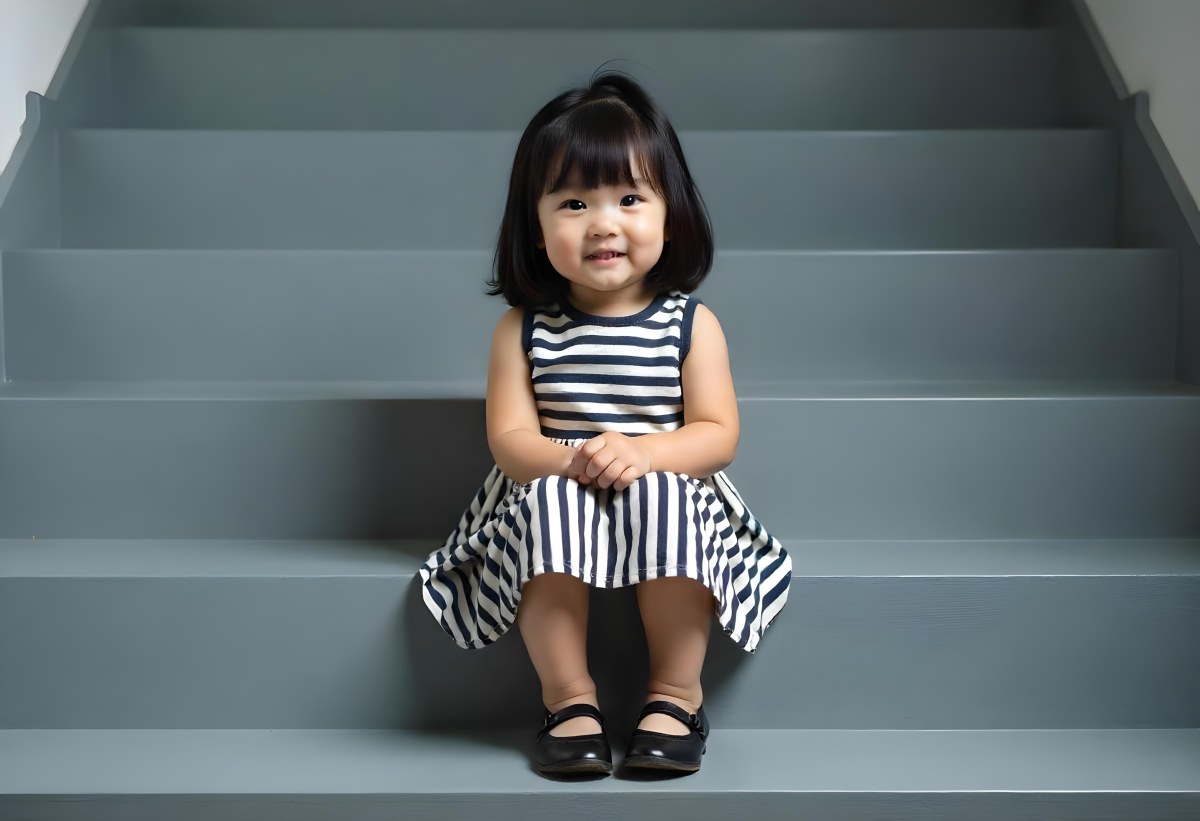 An Asian Girl 6 Years Old Black Hair Sitting On Gray Stairs Wearing A Striped Dress And Black Shoes Gray Background 8 018f