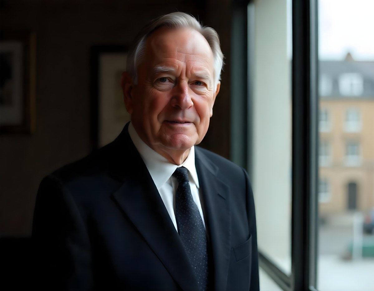 An Elderly Caucasian Man With Gray Hair Wearing A Dark Suit And Tie Standing In Front Of A Window 9 2988