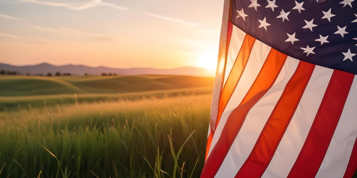 A Close Up View Of An American Flag Against A Scenic Sunset Landscape With A Grassy Field And A Bright Orange Sky 16 C3e3