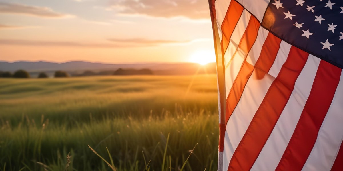 A Close Up View Of An American Flag Against A Scenic Sunset Landscape With A Grassy Field And A Bright Orange Sky 22 E345