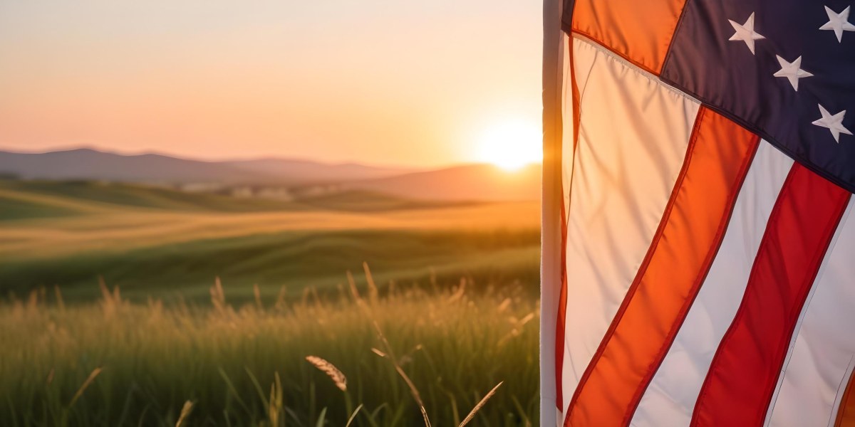 A Close Up View Of An American Flag Against A Scenic Sunset Landscape With A Grassy Field And A Bright Orange Sky 26 89a6