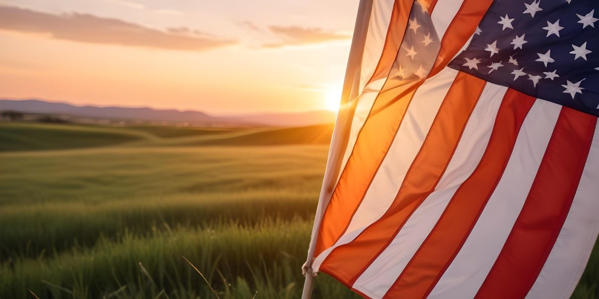 A Close Up View Of An American Flag Against A Scenic Sunset Landscape With A Grassy Field And A Bright Orange Sky 33 7d1d