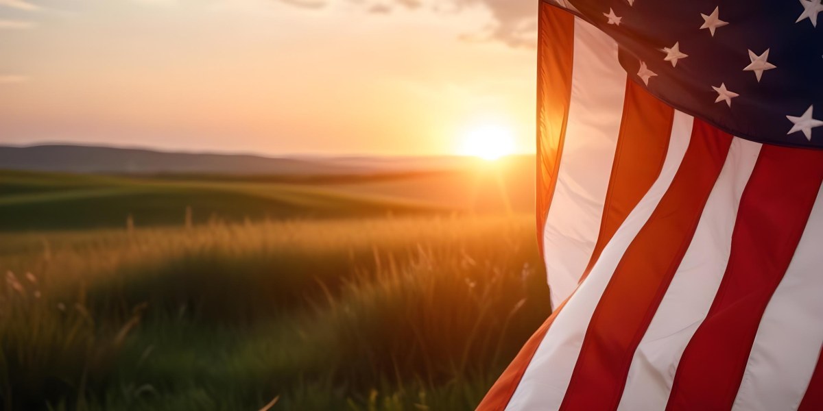 A Close Up View Of An American Flag Against A Scenic Sunset Landscape With A Grassy Field And A Bright Orange Sky 34 F80a