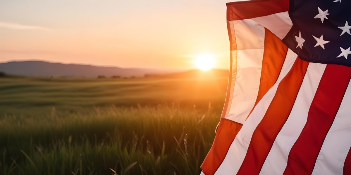 A Close Up View Of An American Flag Against A Scenic Sunset Landscape With A Grassy Field And A Bright Orange Sky 35 7e05