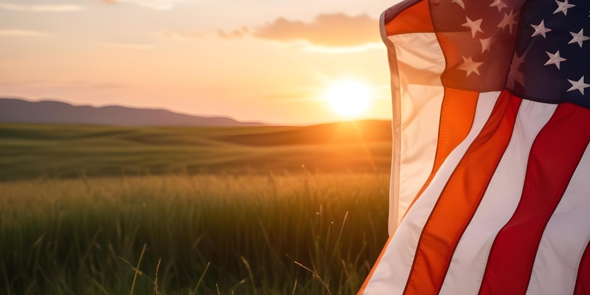 A Close Up View Of An American Flag Against A Scenic Sunset Landscape With A Grassy Field And A Bright Orange Sky 38 B91e