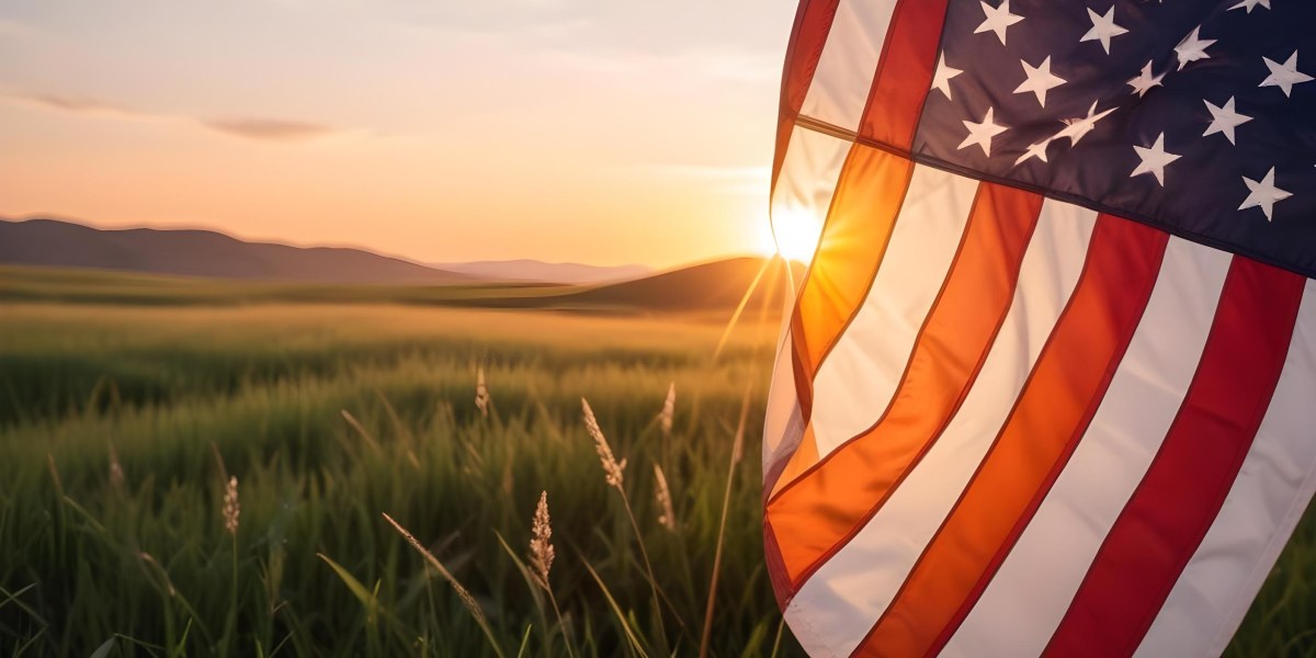 A Close Up View Of An American Flag Against A Scenic Sunset Landscape With A Grassy Field And A Bright Orange Sky 5 Ed78