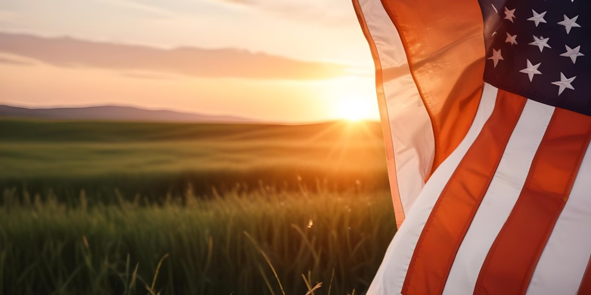 A Close Up View Of An American Flag Against A Scenic Sunset Landscape With A Grassy Field And A Bright Orange Sky 8 2714