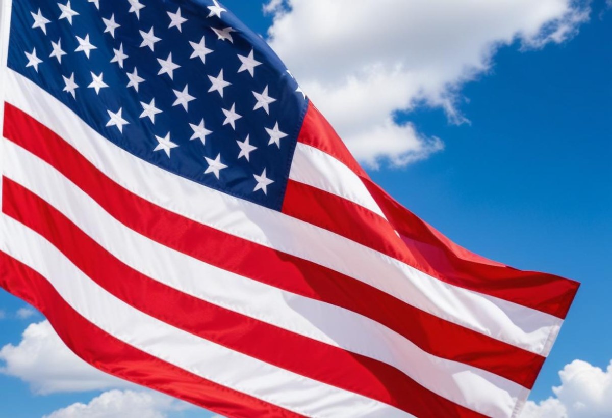 American Flag Waving In The Wind With Its Red And White Stripes And Blue Field Of Stars Against A Blue Sky With White Clouds 28 4ab5