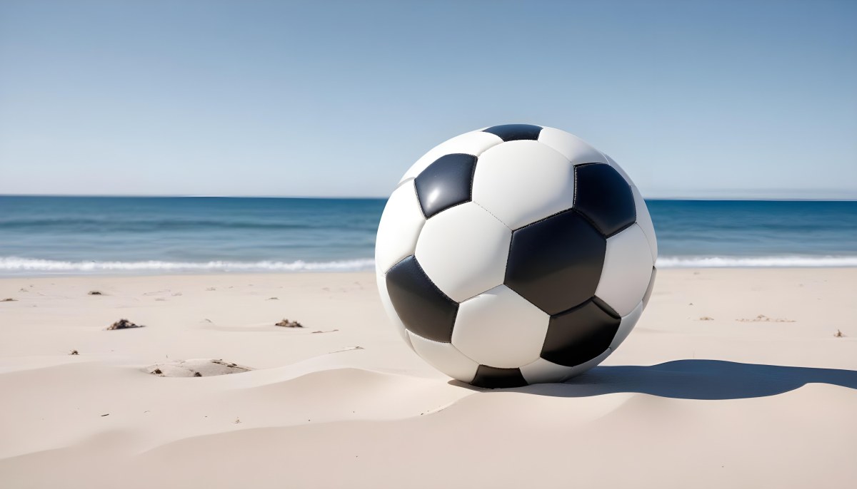 A Classic Black And White Soccer Ball On A Sandy Beach With A Clear Blue Sky And Ocean In The Background 11 0ba3