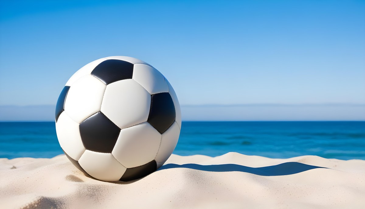 A Classic Black And White Soccer Ball On A Sandy Beach With A Clear Blue Sky And Ocean In The Background 14 62c2