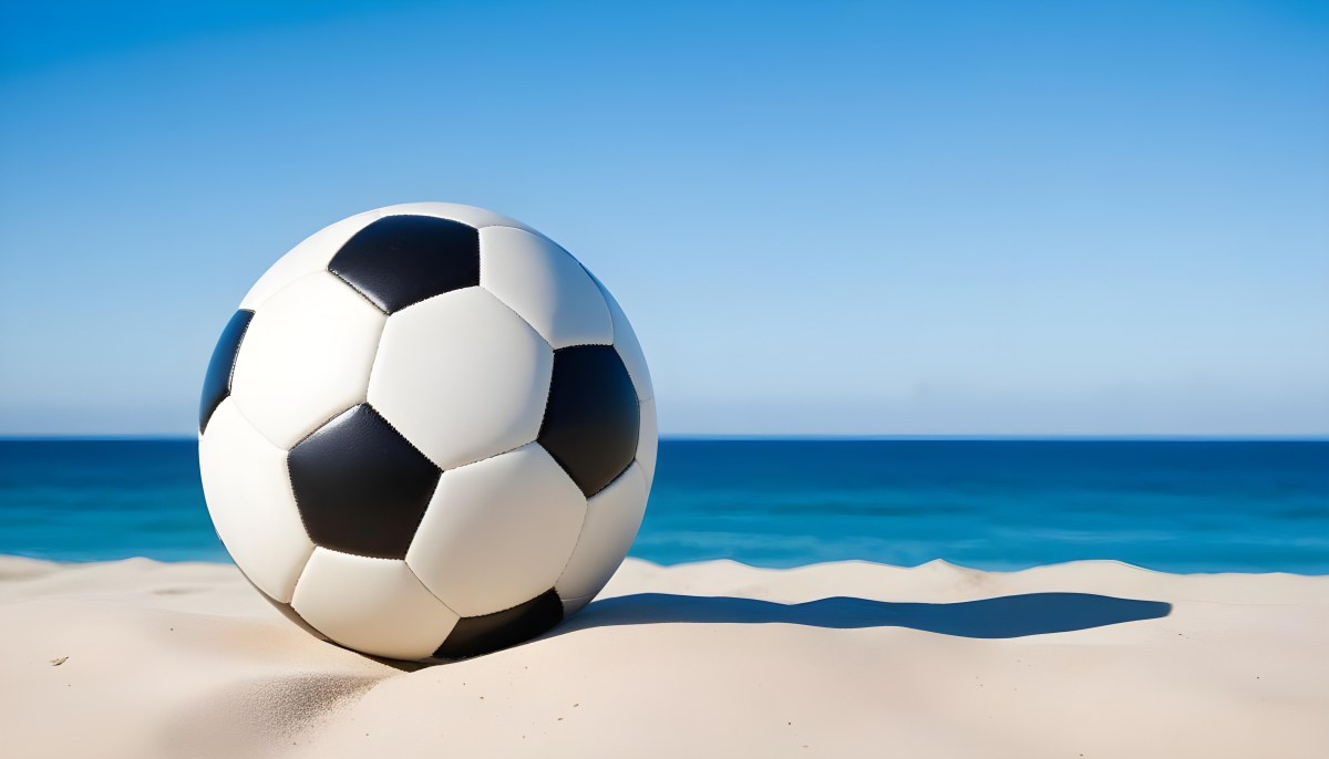 A Classic Black And White Soccer Ball On A Sandy Beach With A Clear Blue Sky And Ocean In The Background 16 2b24