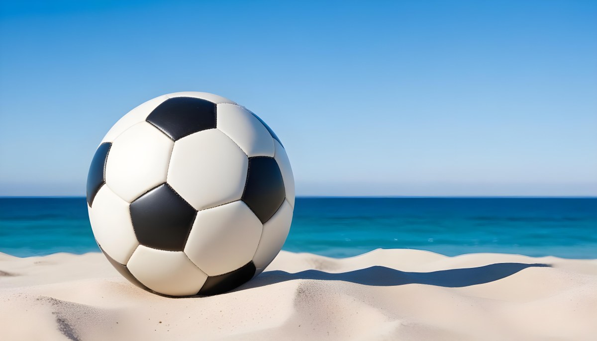 A Classic Black And White Soccer Ball On A Sandy Beach With A Clear Blue Sky And Ocean In The Background 2 8503