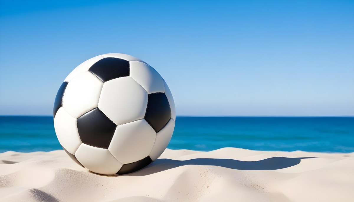 A Classic Black And White Soccer Ball On A Sandy Beach With A Clear Blue Sky And Ocean In The Background 9 7557