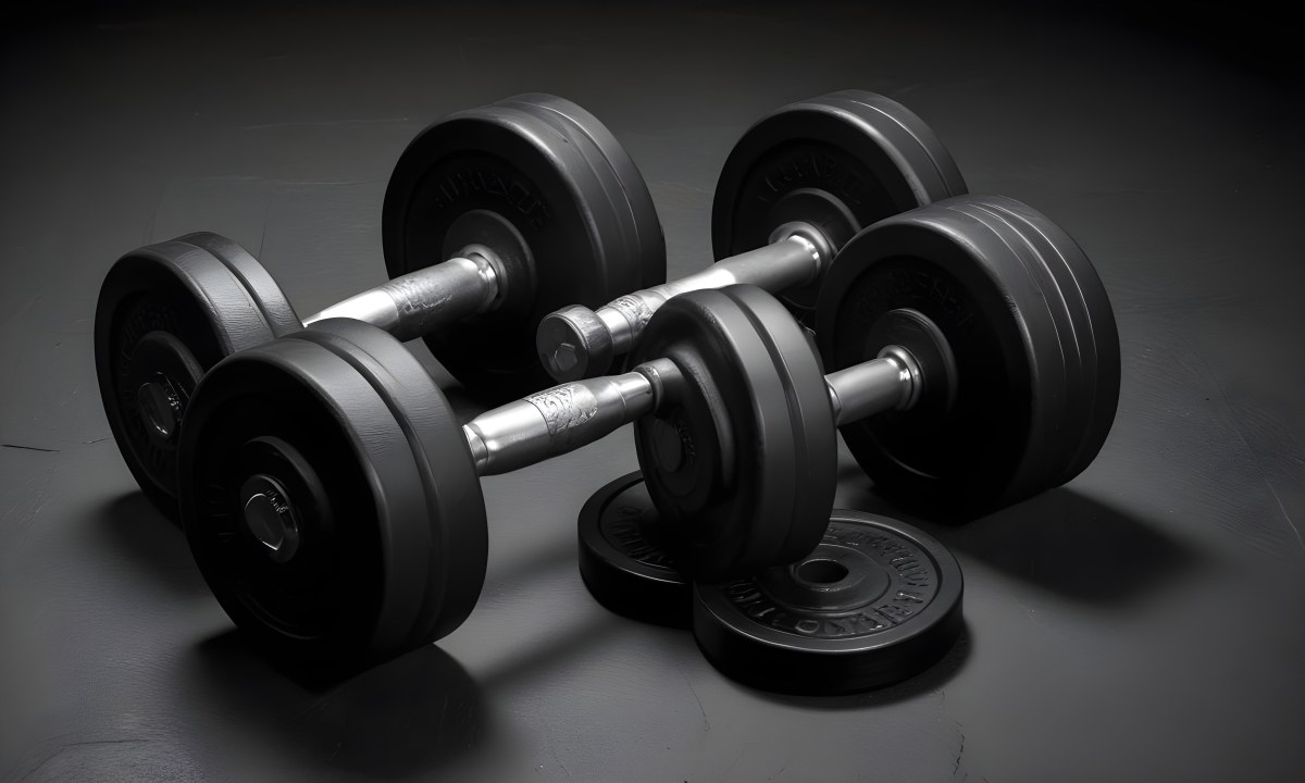 A Pair Of Black Metal Dumbbells With Weight Plates Stacked On A Dark Surface 11 9534