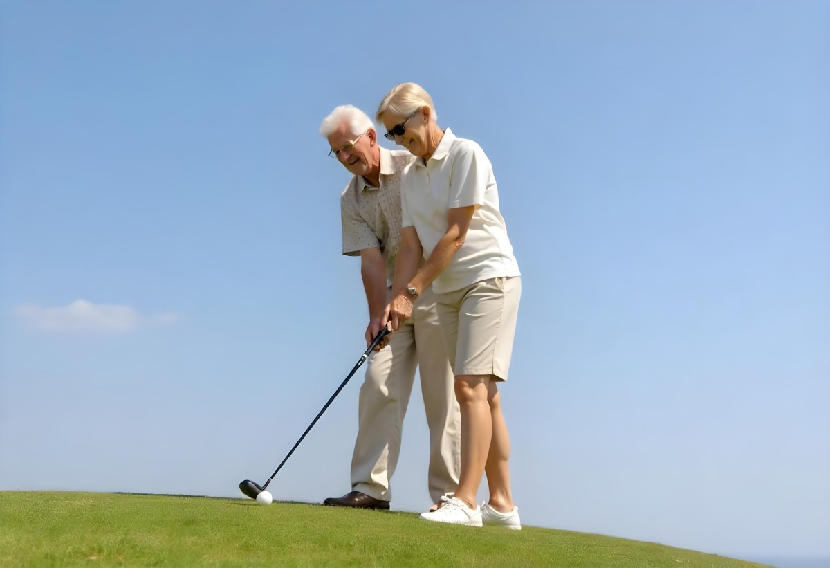 An Elderly Caucasian Couple A Man And A Woman Standing On A Grassy Hill And Holding Golf Clubs 3 F977
