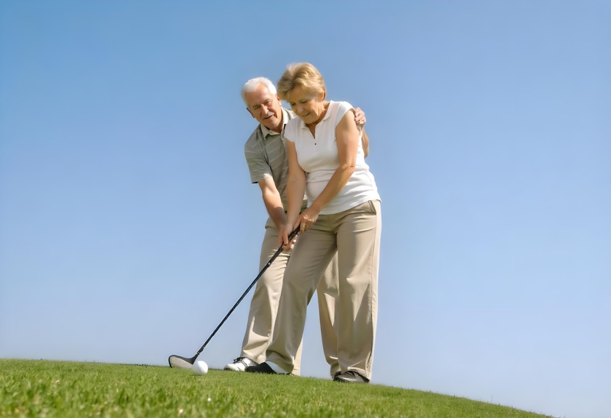 An Elderly Caucasian Couple A Man And A Woman Standing On A Grassy Hill And Holding Golf Clubs 6 82e1
