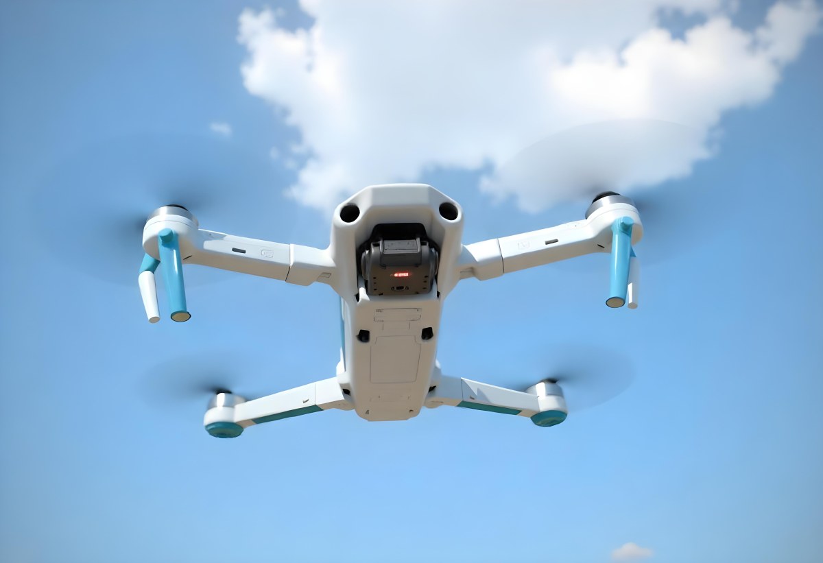 A Blue Dji Mini 3 Pro Drone With Blue Propellers In Mid Air Against A Bright Blue Sky With Scattered White Clouds 15 754b