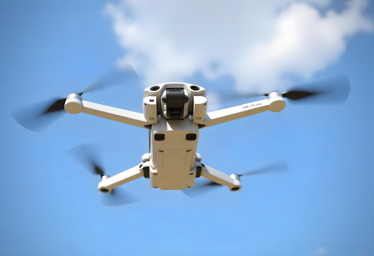 A Blue Dji Mini 3 Pro Drone With Blue Propellers In Mid Air Against A Bright Blue Sky With Scattered White Clouds 6 A3ac