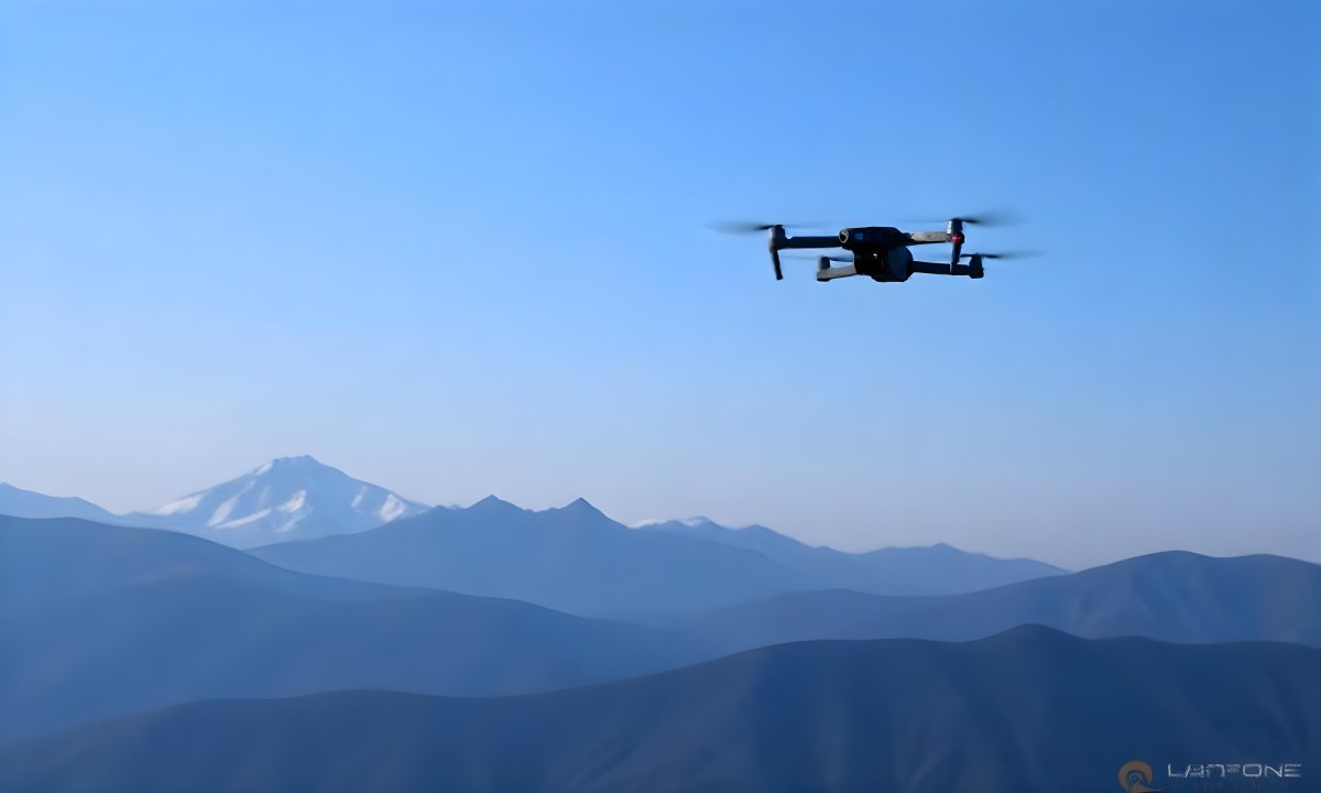 A Blue Drone Flying Over The Mountains With Mountains In The Background And A Clear Blue Sky 20 8317