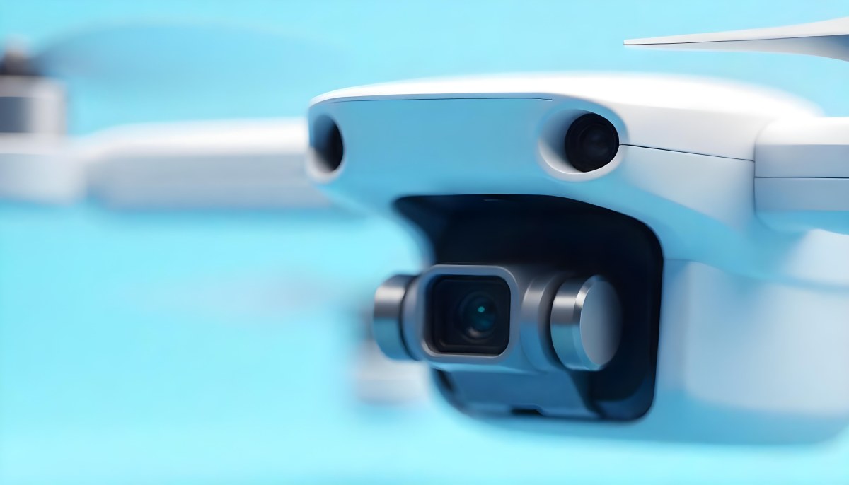A Close Up Of A Drone Camera With A Lens And Blue Body Mounted On A White Drone With A Light Blue Background 9 5cc7