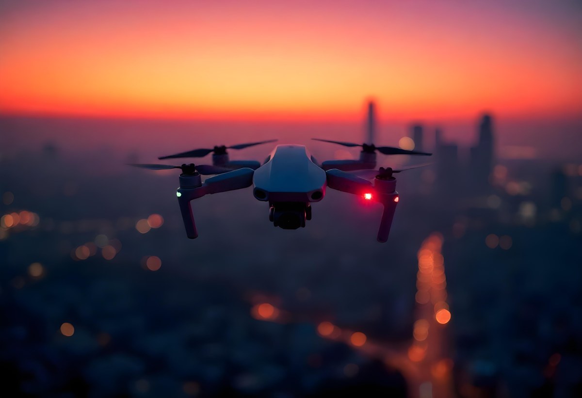 A Drone Flying Over A City At Night The City Is Illuminated With Lights The Sky Is A Mix Of Orange And Purple 2 62c1