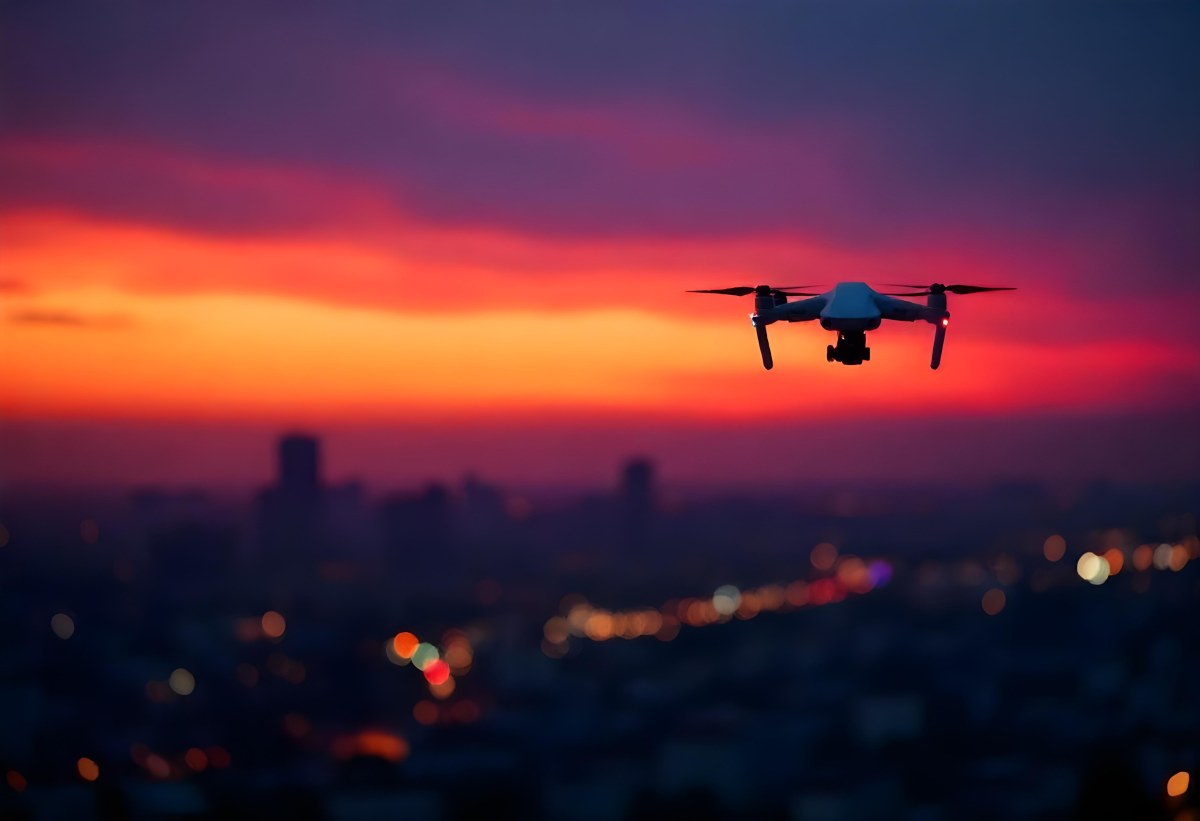 A Drone Flying Over A City At Night The City Is Illuminated With Lights The Sky Is A Mix Of Orange And Purple 6 1d7d