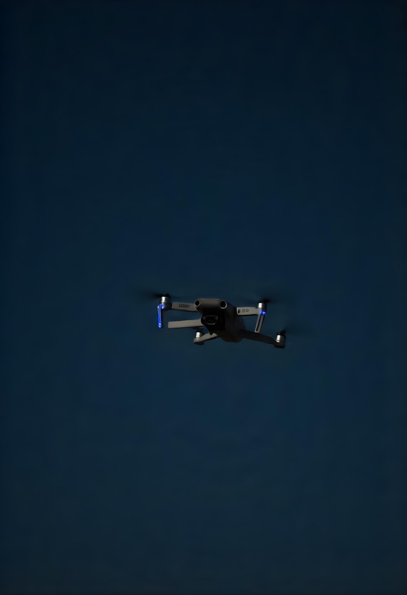 A Gray Mavic 2 Drone With Blue Propellers In The Air The Sky Is Black 8 9bd3