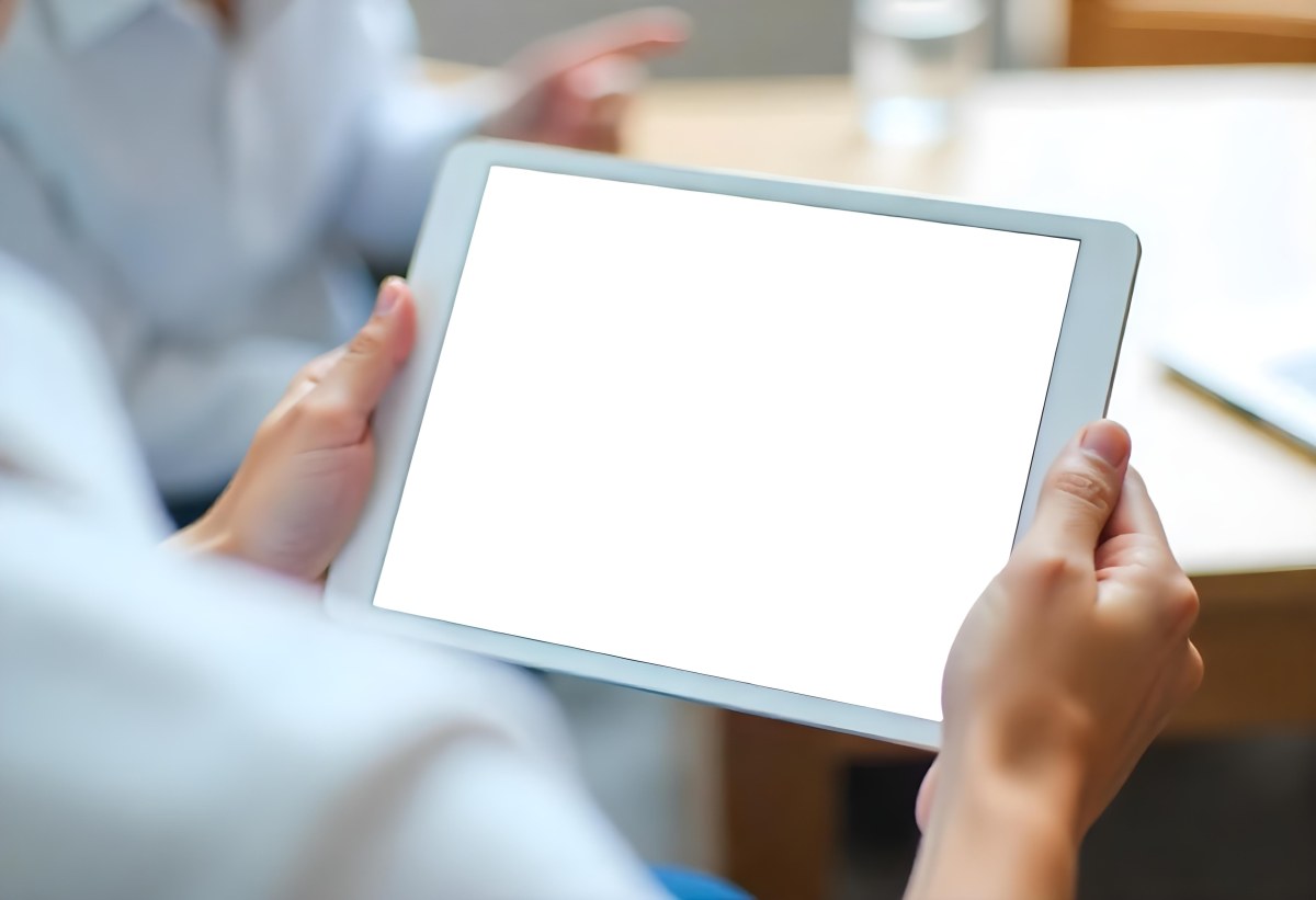 A Person Holding A Tablet With A Blank Blue Screen The Background Is Blurred And Out Of Focus The Person Is Wearing A White Shirt 6 718a