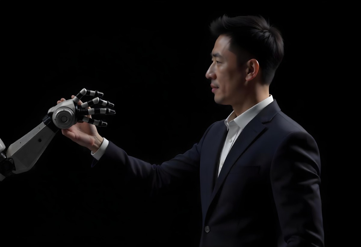 An Asian Man 35 Years Old With Black Hair Wearing A Suit Reaching Out To A Robot Arm In A Black Background 5 2cf4