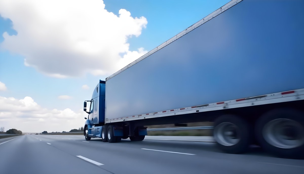 A Blue Semi Truck On A Highway With Motion Blur The Sky Is Black With Some Clouds Daytime 12 4a82
