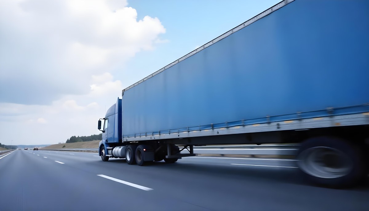 A Blue Semi Truck On A Highway With Motion Blur The Sky Is Black With Some Clouds Daytime 15 C547